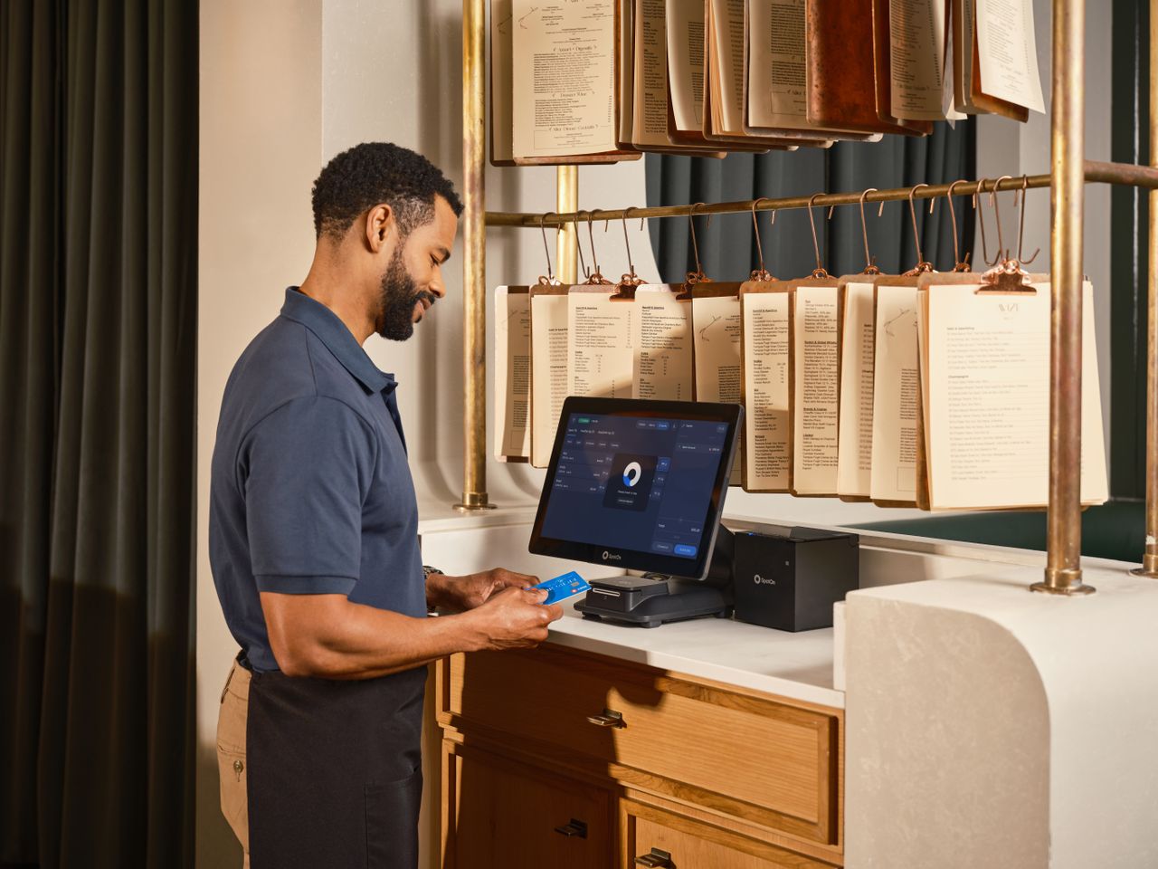 Server using a point of sale system to process a credit card payment in a restaurant setting.